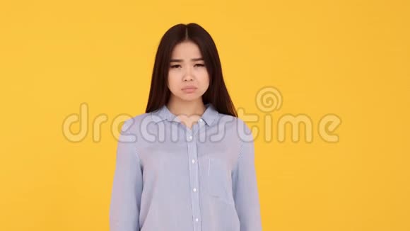 少女亚洲不开心露出嫌弃的姿态黄色背景的女人视频的预览图