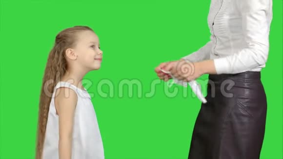 母亲和女儿戴着外科口罩以防止在绿色屏幕上流行视频的预览图