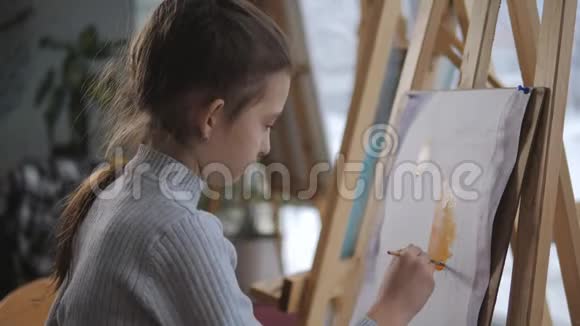 艺术学校的女孩在画架前画了一幅水彩画视频的预览图
