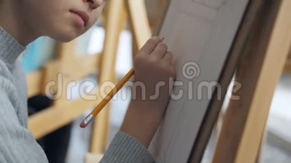 艺术工作室里女孩的特写在画架上画了一幅铅笔素描视频的预览图