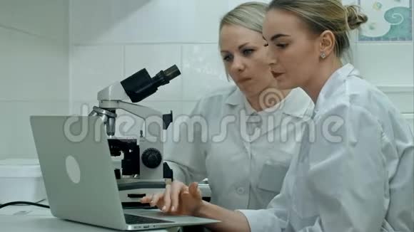 两位年轻的积极科学家利用显微镜和笔记本电脑在实验室工作视频的预览图