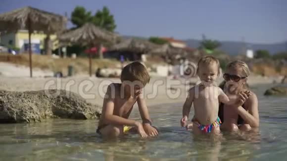 妈妈带着两个孩子在清澈的海水里洗澡克罗地亚视频的预览图