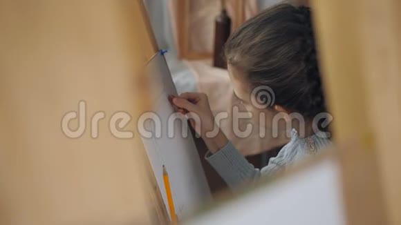 画画学校的女孩学画静物女孩用铅笔在一张纸上画素描的特写视频的预览图