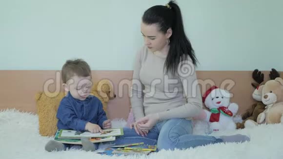 一个孩子在妈妈旁边坐在沙发上看书视频的预览图