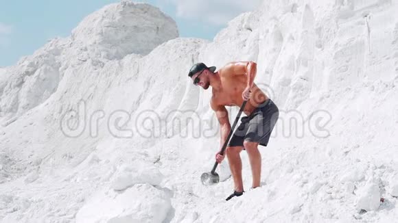 肌肉发达的赤膊男子在白色采石场用大锤做运动视频的预览图