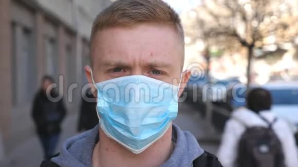 戴着医用口罩的年轻人的肖像立在城市街道上在户外戴防病毒面具的人视频的预览图