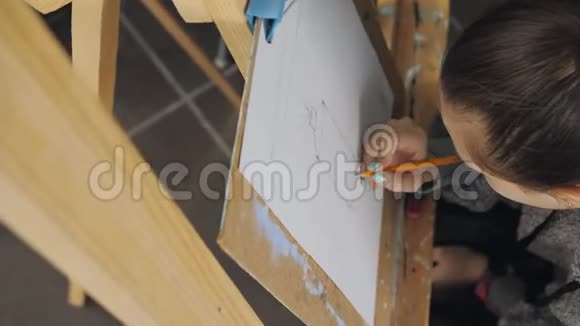 画架上的艺术工作室里的一个十几岁的女孩画着平静的生活视频的预览图