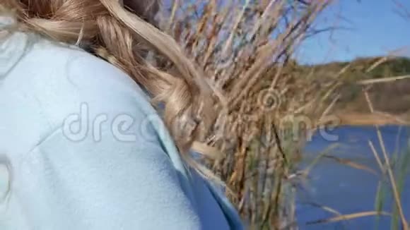 一位年轻女子吹金发的特写镜头视频的预览图