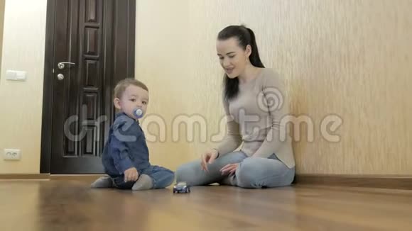 幼儿玩妈妈玩具车坐在地板上视频的预览图