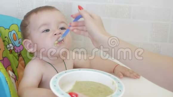 小孩坐在喂食椅上吃粥视频的预览图
