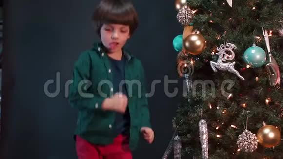 圣诞节时在圣诞树附近跳舞的男孩视频的预览图