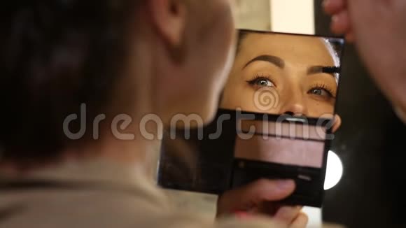 女人涂睫毛膏看着镜子视频的预览图