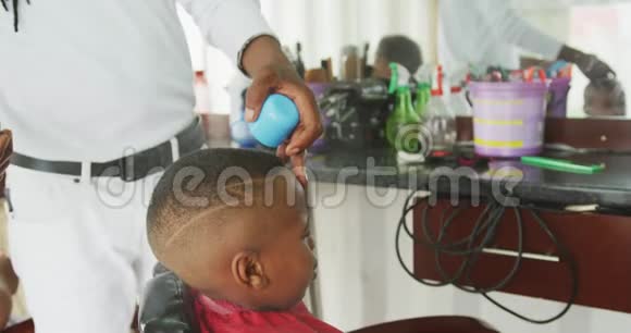 非洲男人为非洲男孩的头发整理视频的预览图