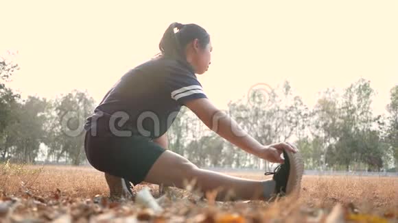 亚洲年轻女子在公园慢跑前伸展腿以保持身体健康保健概念视频的预览图