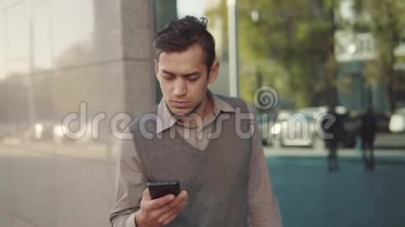 一个英俊的年轻人在城里走来走去打电话视频的预览图