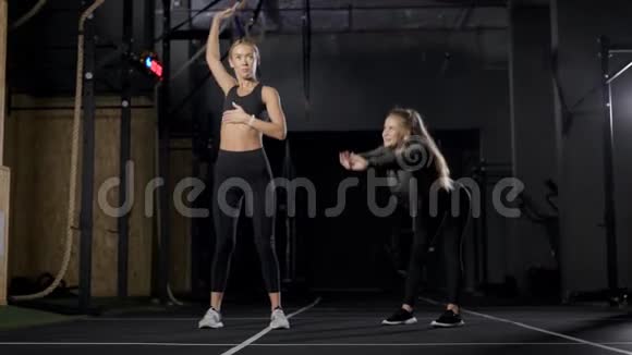 有魅力的女运动员晚上在体操馆锻炼伸展和温暖肌肉视频的预览图