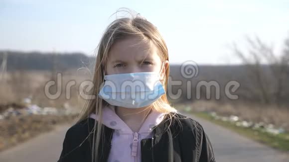 戴着医用口罩的小女孩站在户外的肖像快乐女孩子摘下防毒面具视频的预览图
