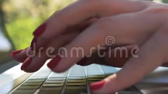 女性手在笔记本电脑键盘上输入一些文字在户外笔记本上工作的女人女孩和别人聊天或者视频的预览图