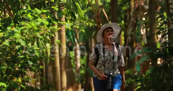 印度果阿阳光明媚的一天年轻的背包客旅游妇女在热带丛林森林里散步和拍照女士视频的预览图