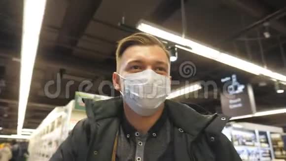 带着医用口罩在超市散步的年轻人的肖像带着防毒面具去商店的人视频的预览图