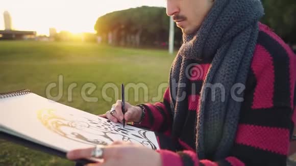 现代年轻时尚男画家在公园画素描视频的预览图