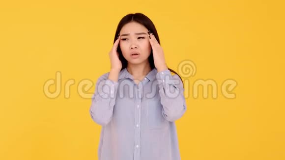 黄色背景的亚洲少女妇女头痛的概念视频的预览图