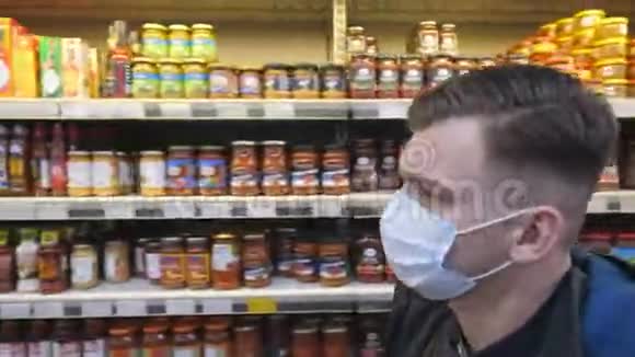 带着医用口罩的年轻人在超市散步带着防毒面具去商店的人视频的预览图