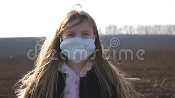戴着医用口罩的小女孩站在户外的肖像可悲的女孩子戴着防毒面具视频的预览图