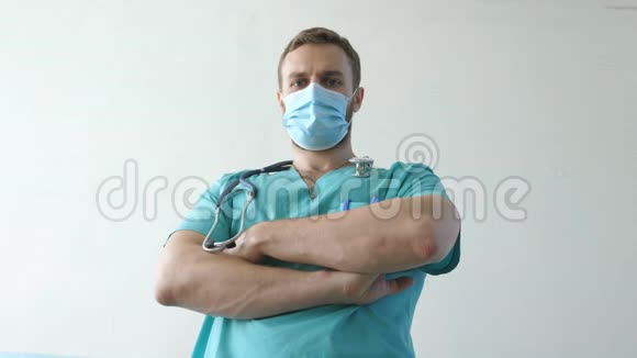 年轻男性白种人医生戴着医用面罩的肖像看着镜头戴防护面罩的医务人员视频的预览图
