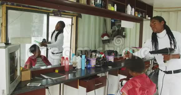 非洲男人给非洲女人的头发做造型视频的预览图
