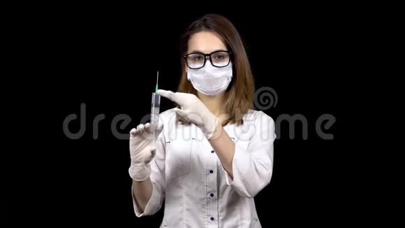 年轻的女医生正拿着装满药物的注射器站着一位医生从注射器里喷出来以释放空气视频的预览图