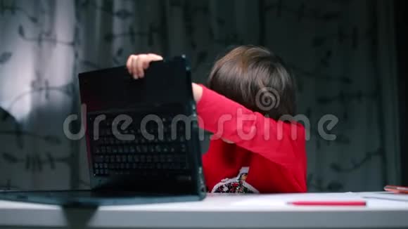 一个男孩坐在桌子旁修理笔记本电脑视频的预览图