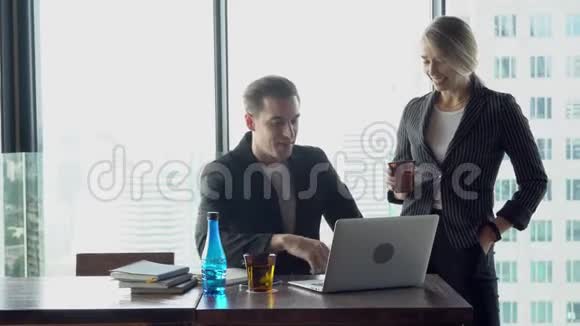 女商人和商人一起用笔记本电脑开会讨论视频的预览图