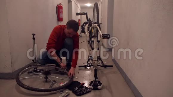 一位父亲正在车库里修理一辆儿子自行车的轮子视频的预览图