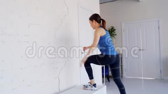 穿蓝色t恤的女孩在家从事健身训练视频的预览图