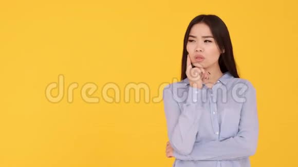 黄色背景的亚洲女孩一个体贴的人和一个聪明的想法视频的预览图