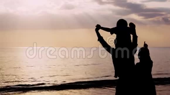 快乐的亚洲家庭在晚上一起度假在海滩上看日落父母和孩子快乐休闲视频的预览图