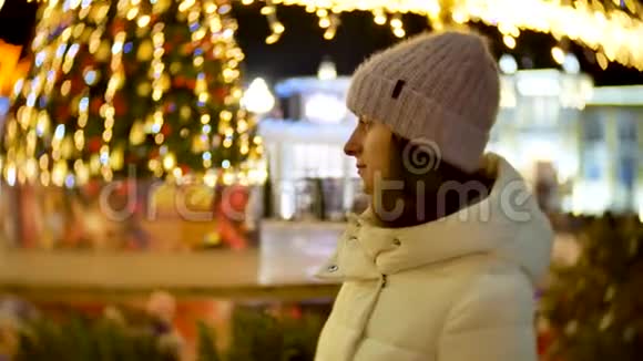 圣诞彩灯背景下的冬天美丽少女画像视频的预览图
