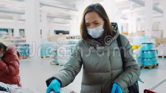 一个女人带着一个女儿穿着冬天的衣服在商店里戴着在商店里买干李子干果视频的预览图