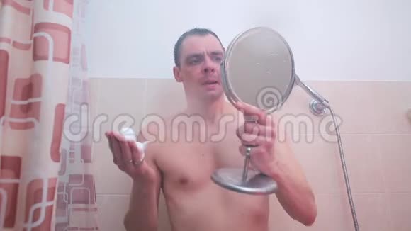 浴室里的一个人正在脸上撒着剃须泡沫视频的预览图