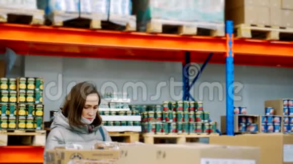 一个妇女是在一个批发食品仓库通过产品采购的穿冬天衣服的女人和商店里的医疗面具视频的预览图