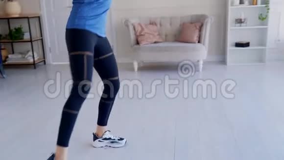 穿蓝色t恤的女孩在家从事健身训练视频的预览图