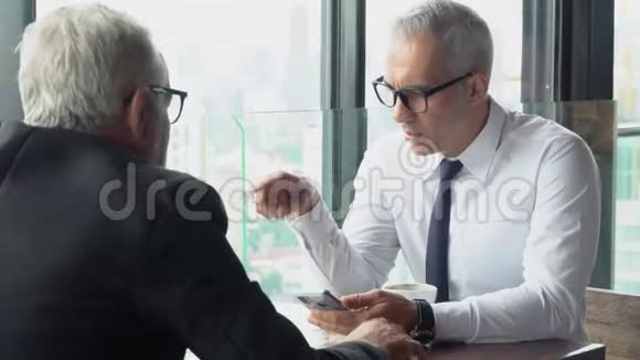两位高级商人讨论了在办公室的工作行政会议和成功的对话视频的预览图