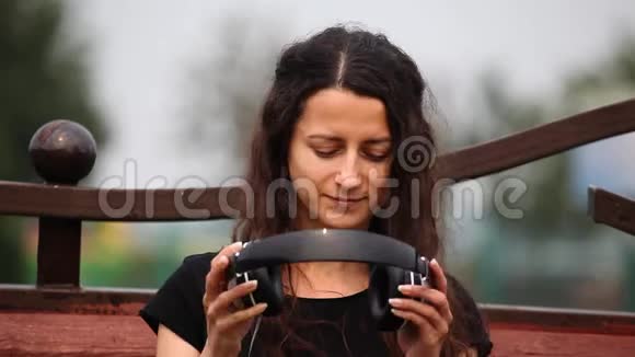 一位年轻女子戴着耳机听音乐摘下耳机视频的预览图