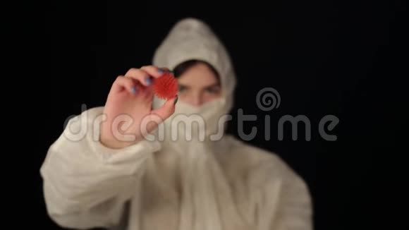 一名身穿防护服的白人女医生指着摄像机上的冠状病毒COVID19模型黑暗的视频的预览图