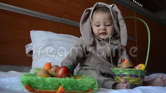 可爱的宝宝穿着兔子服装玩复活节彩蛋关门视频的预览图