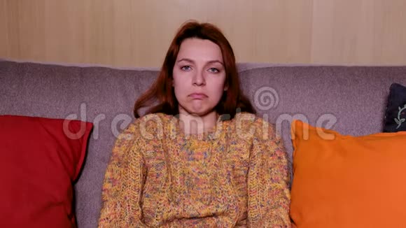 一个年轻女人看一部悲伤而情绪化的电影的特写视频的预览图