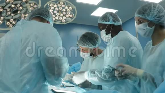 一个国际团队的医生对麻醉下的病人进行复杂的外科手术现代运作视频的预览图
