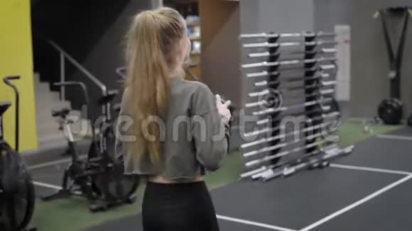 年轻的女运动员正在穿过体操馆走向举重准备锻炼视频的预览图