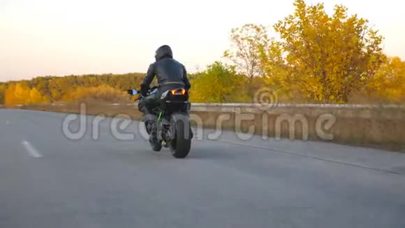 在秋天的高速公路上骑着现代摩托车的人面目全非摩托车手在乡下骑摩托车视频的预览图